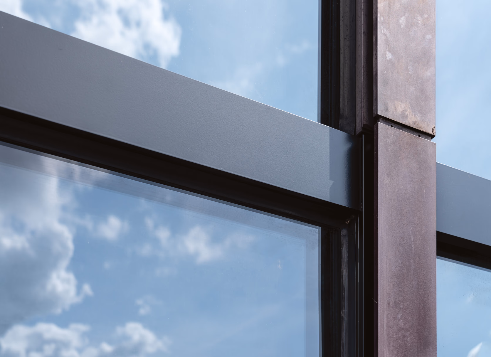 Nahaufnahme eines folierten Aluminiumprofils der Pfosten-Riegel-Fassade gegen den Himmel