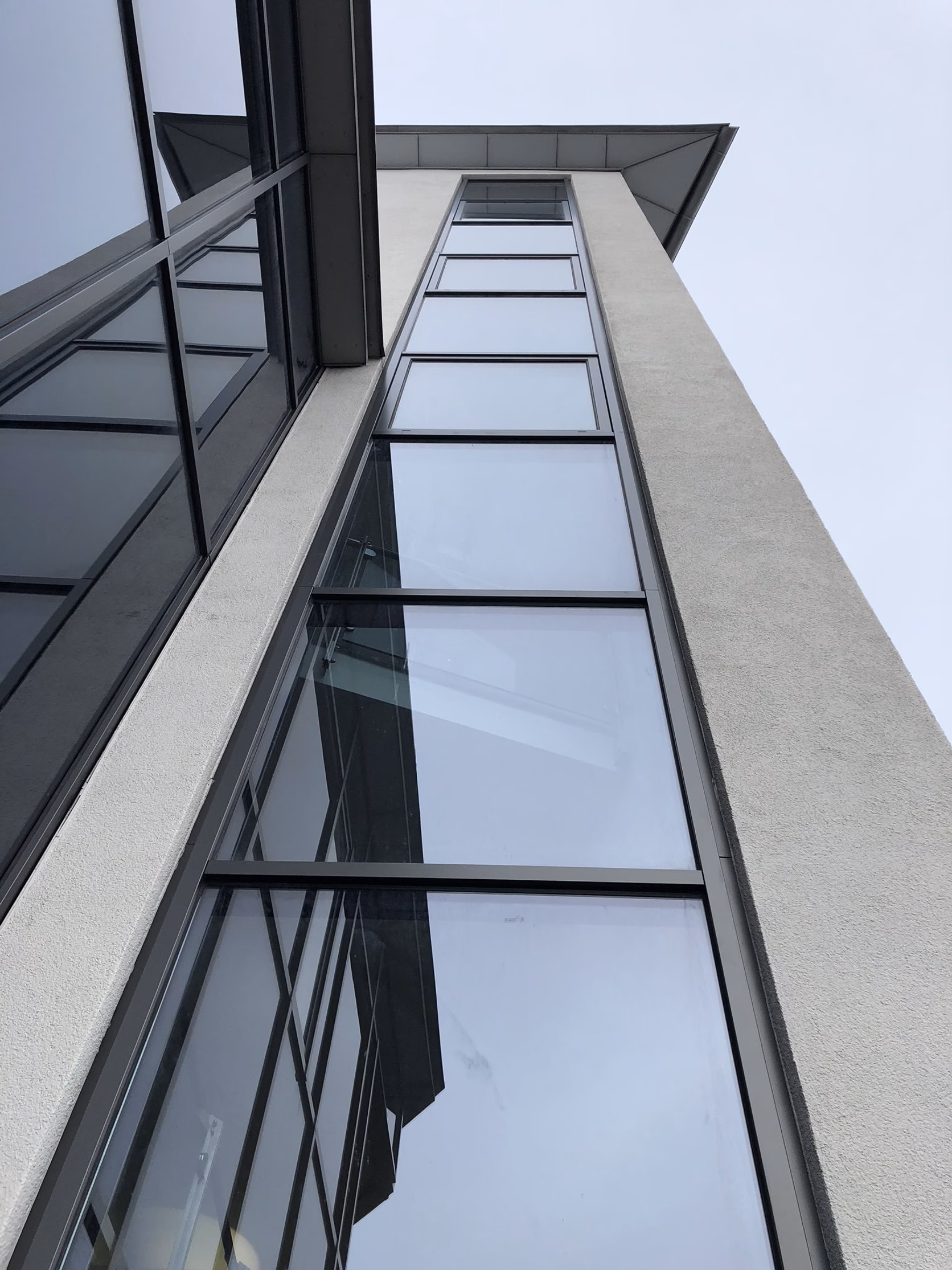 Vertikales Fensterband an einem Treppenhausturm der Münchner Gewerbeimmobilie nach der Folierung in Anthrazit