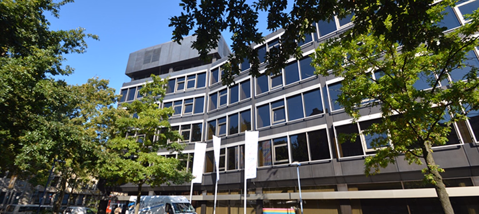 Das Bürogebäude in Offenbach vor der Folierung mit grauen, verwitterten Fassadenbändern