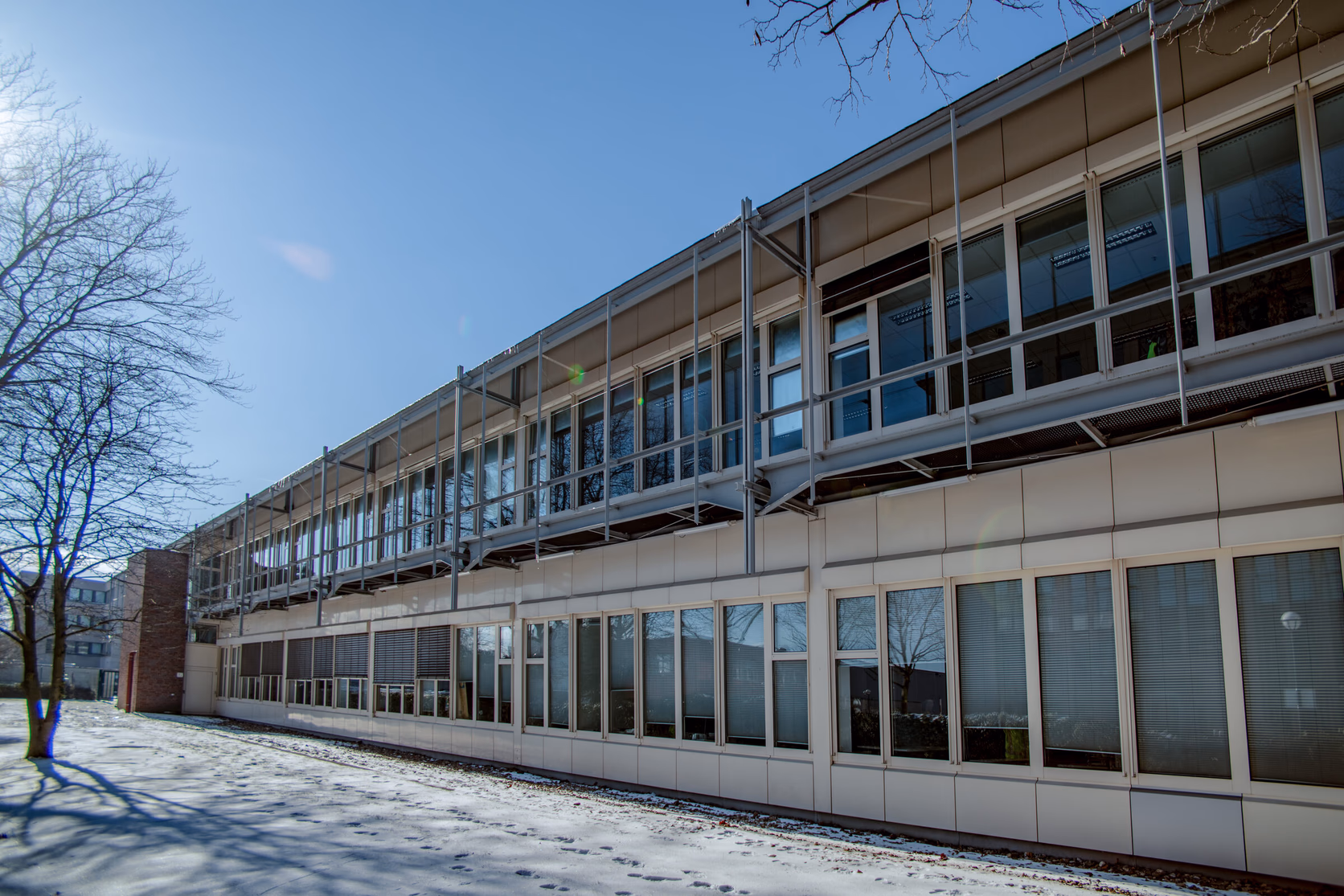 Das Bürogebäude im Winter mit Schnee auf dem Vorplatz während der Sanierungsphase