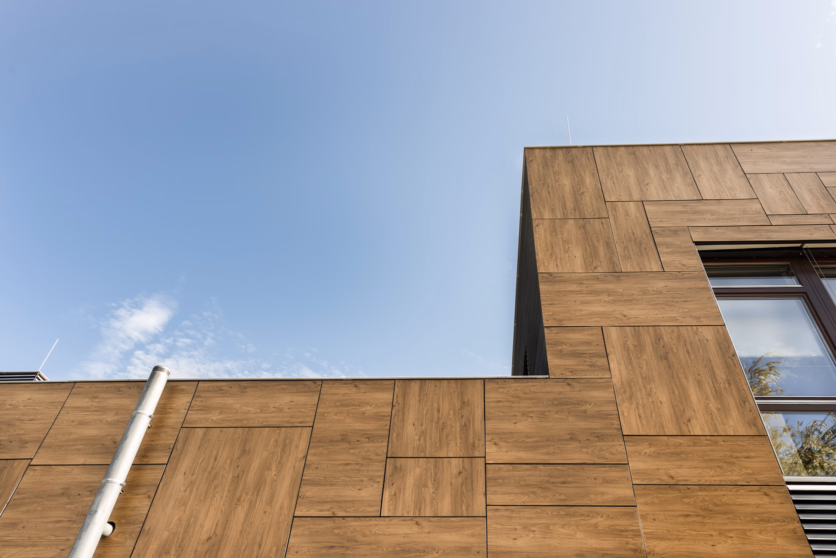 Fassadendetail in Holzdekor, Paneele im Anschnitt gegen den Himmel