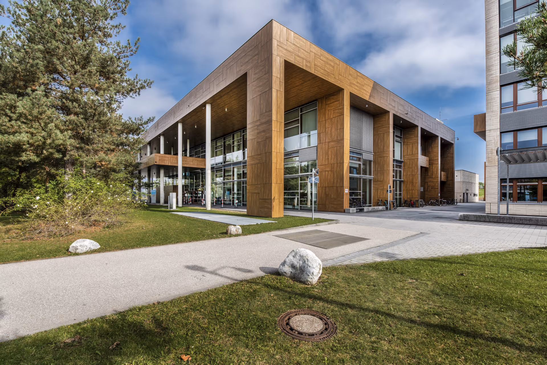 Bürogebäude eines Technologiecampus mit Fassade in Holzdekor, umgeben von Grünanlagen